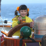 A Little Girl in Pigtails Driving the Jolly Breeze Ship During a Whale Watching Adventure, New Brunswick