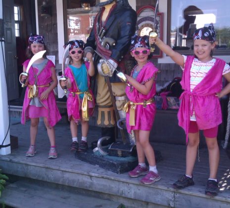 A Group of Four Pink Pirate Girls Showing off Their Swords to the Jolly Breeze Pirate in Saint Andrews, New Brunswick