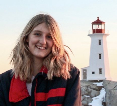 A Photo of a Smiling Whale Watching Crew Near the Ocean with a Lighthouse in the Background, Saint Andrews, New Brunswick
