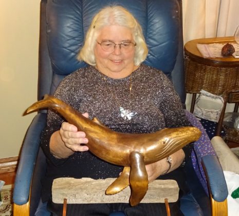 A Jolly Breeze Crew Member Holding a Carved Wooden Humpback Whale Sculpture, New Brunswick